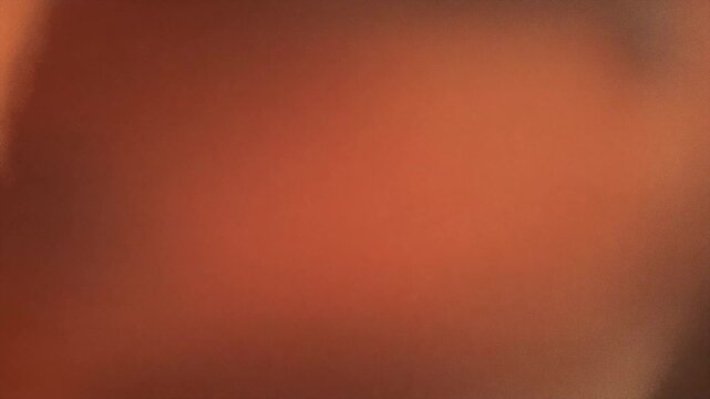 Blurred orange hue fills the entire frame. Soft focus creates a warm, undefined atmosphere. Vague shape suggests movement or gentle motion. Ambient glow evokes calm, cozy, or intimate mood