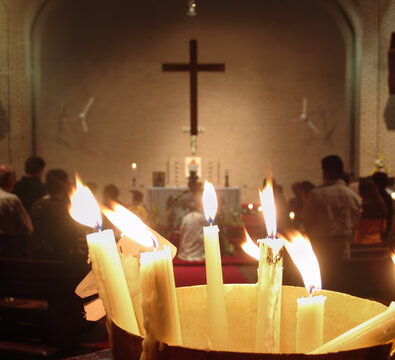 Orthodox Easter Paschal Vigil with Burning Candles with Blurred Cross and Congregation interior with a dark cross