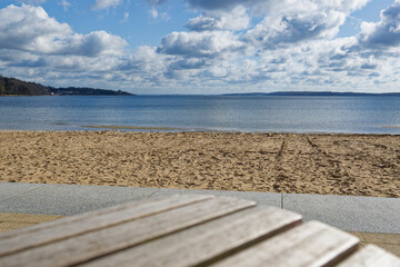 Fototapeta premium Peaceful sandy beach wassersleben with calm water and cloudy blue sky on a bright day