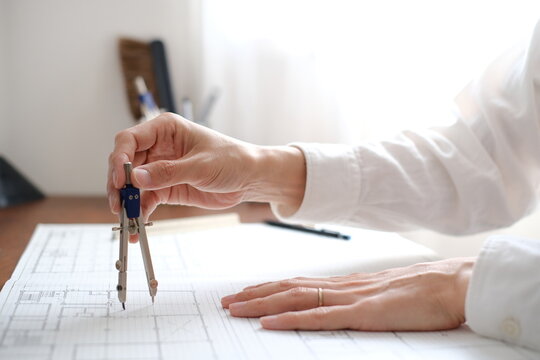 建築士が製図作業を行う手元　コンパスを使った建築設計図の作成 An architect working on a drawing