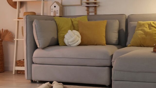 Stylish modular sofa and other furniture in room. Camera moving left