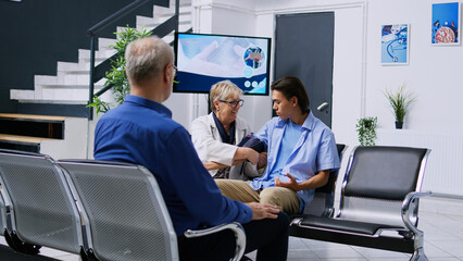 Fototapeta premium Senior specialist doing cardiology exam with tonometer to measure patient hypertension and hypotension, checking blood pressure with instrument. Doctor measuring asian man high or low pulse