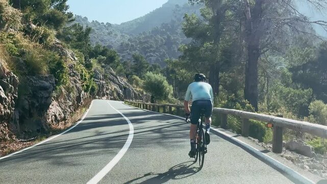 Man Cycling on Scenic Mountain Road in Mallorca Spain
