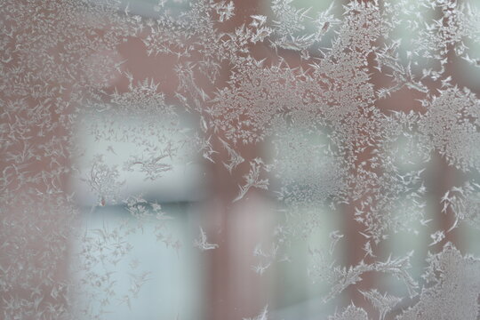 Beautiful frost crystals on a window glass in winter.