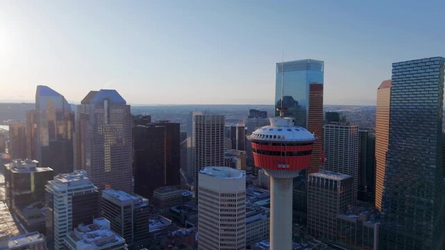 Aerial orbit of the Calgary Tower at sunrise, showcasing the modern downtown skyline and urban architecture in Calgary, Alberta, Canada.
