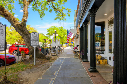 American flags and historical markers outside of sidewalk cafes and shops along picturesque Front Street, the main street through the historic early American town of Georgetown, South Carolina.