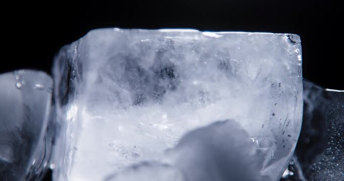 Ice cube closeup over black background. Real ice structure.