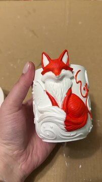 A handmade ceramic cup featuring a relief design of a red fox, crafted by the artist