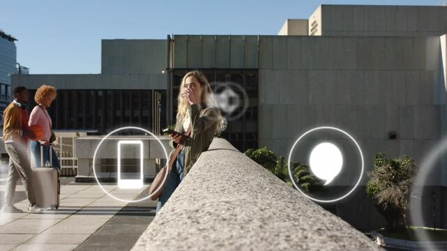 Woman tapping phone checking mail in plaza, causing floating tech icons cycling with pair passing