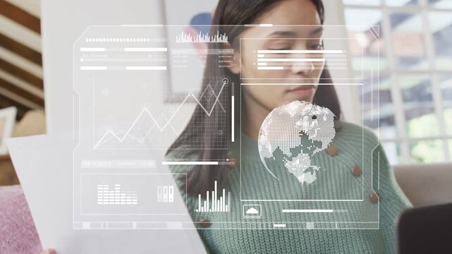 Woman on sofa bringing paper closer and cross-checking data with laptop, activating business charts