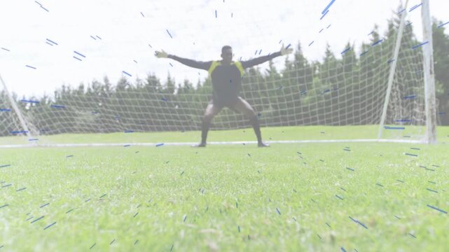 Soccer goalkeeper sprinting to mid goal bracing to defend goal as attacker sliding to reach ball