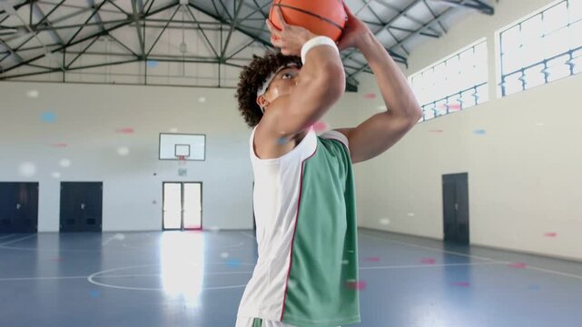 Male athlete shifting grip, practicing free-throw while animated confetti tracing shot arc