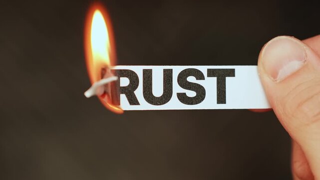Burning &ldquo;TRUST&rdquo; concept symbolizing betrayal, broken relationships, emotional pain, deception, lost confidence, and the end of loyalty in personal or business life.