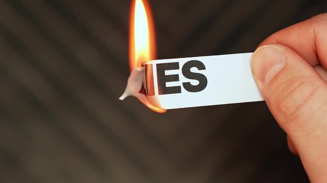 Burning &ldquo;lies&rdquo; label held by hand, symbolizing truth, honesty, openness, and freedom from deception, secrecy, and false narratives.