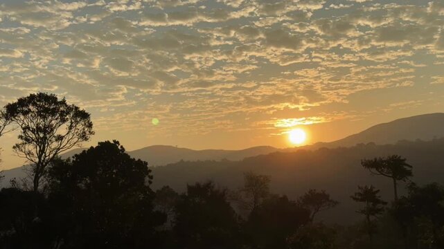 Golden sunrise lights up the Western Ghats of India, painting misty peaks, green valleys, and drifting clouds in a breathtaking moment of pure morning serenity.
