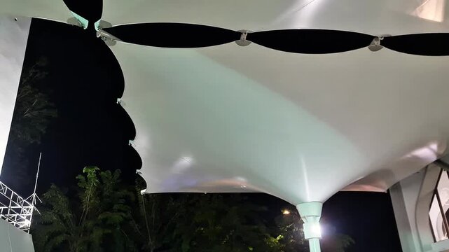 Automated Large Tensile Umbrella Structure Opening at Night for Weather Protection and Architectural Lighting