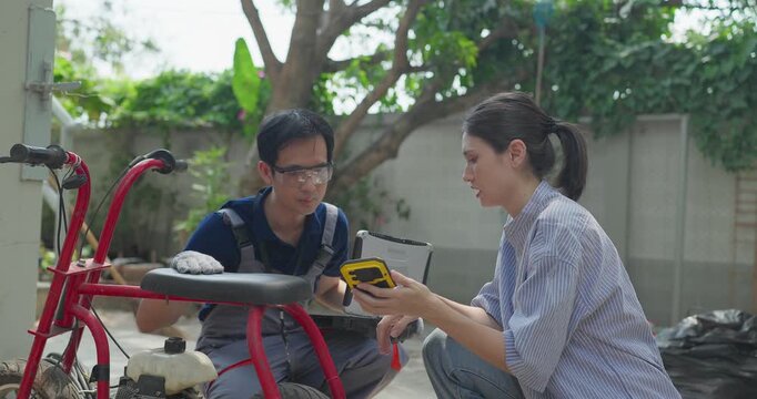Startup founder and engineer inspect, document and test a minibike prototype outdoors at small business workshop during product development, repair review and SME innovation.
