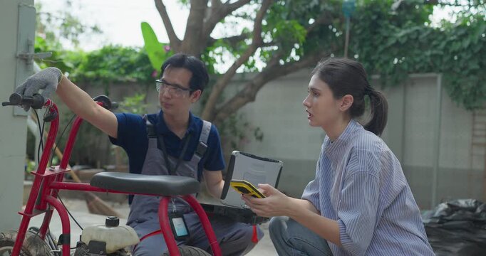 Startup founder and engineer inspect, document and test a minibike prototype outdoors at small business workshop during product development, repair review and SME innovation.
