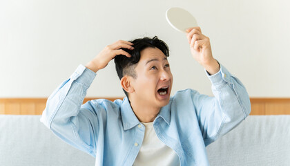 Naklejka premium 薄毛や抜け毛に悩む男性のヘアトラブルイメージ, Man Worried About Hair Loss Looking in Mirror