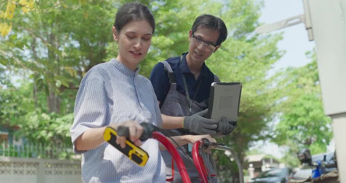 Startup founder and engineer inspect, document and test a minibike prototype outdoors at small business workshop during product development, repair review and SME innovation.
