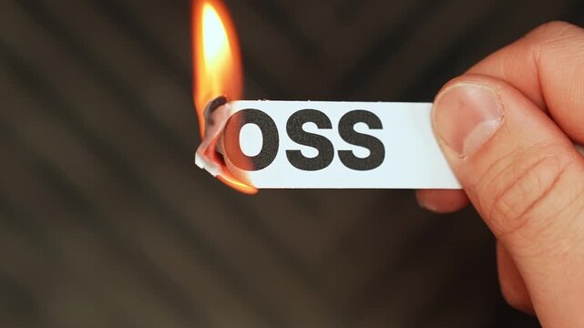 Burning &ldquo;loss&rdquo; label held by hand, symbolizing recovery, protection, regained stability, and moving from setback toward security, profit, and renewal.