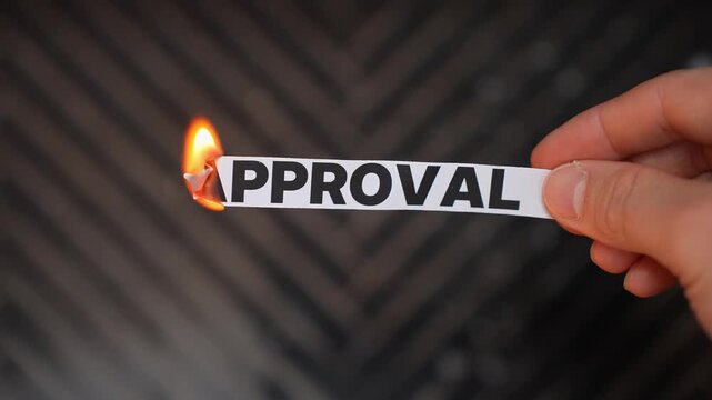 Burning &ldquo;APPROVAL&rdquo; concept symbolizing self-acceptance, confidence, independence, and freedom from people pleasing, validation seeking, and outside judgment.
