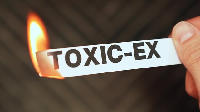 Burning &ldquo;toxic-ex&rdquo; label held by hand, symbolizing closure, emotional healing, healthy boundaries, and moving forward after an unhealthy relationship.