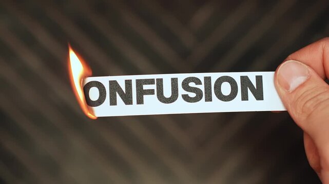 Burning &ldquo;confusion&rdquo; label held by hand, symbolizing mental clarity, clear decisions, focus, and release from uncertainty, doubt, and scattered thinking.