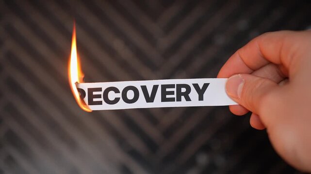 Burning &ldquo;RECOVERY&rdquo; concept symbolizing relapse, setback, decline, stalled progress, and the loss of healing, growth, stability, or economic improvement.