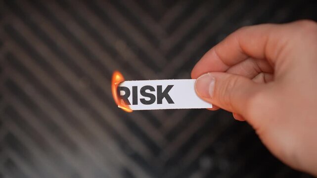 Burning &ldquo;RISK&rdquo; concept symbolizing safety, stability, protection, secure choices, and freedom from danger, uncertainty, loss, and harmful exposure.