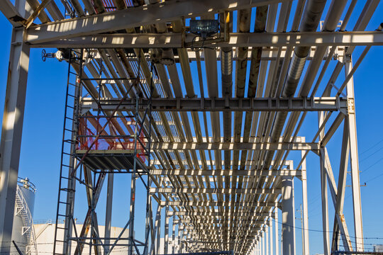 Industrial pipes and scaffolding under blue sky
