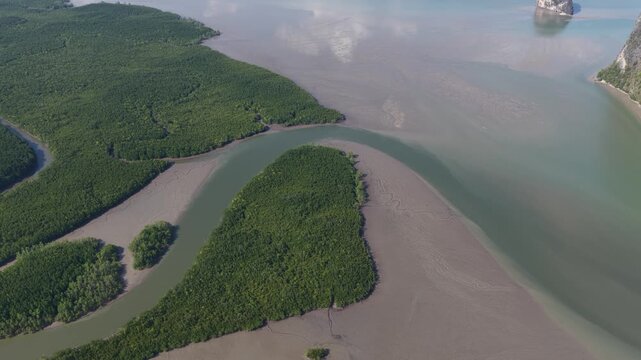 Spectacular aerial view over lush mangrove estuary and winding river revealing dramatic limestone karst islands of phang nga bay, thailands iconic tropical coastline
