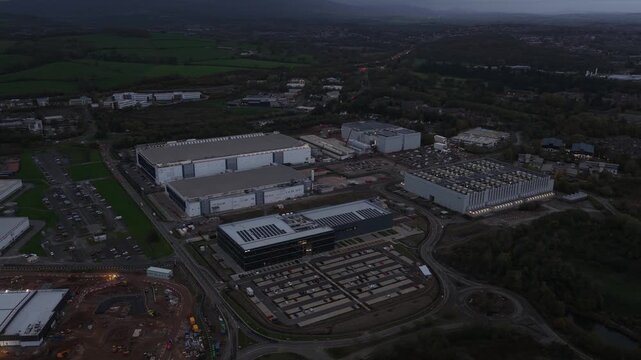 Aerial view of a data center campus in Cardiff at dusk, showing massive hyperscale digital infrastructure, cloud computing facilities, and large scale technology architecture in evening ligh