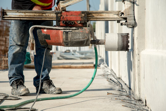 Construction worker coring concrete