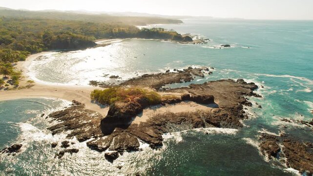 Aerial view of coastal peninsula surrounded by sparkling ocean and sandy beaches