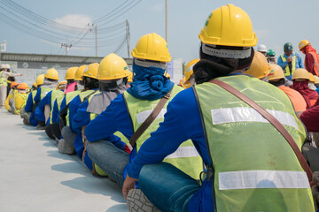 Group of construction worker helmet and safety uniform meeting on morning talk before work at warehouse under construction site © Rassarin