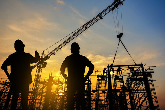 silhouette construction worker Concrete pouring during commercial concreting floors of building in construction site and Civil Engineer or Construction engineer inspec work