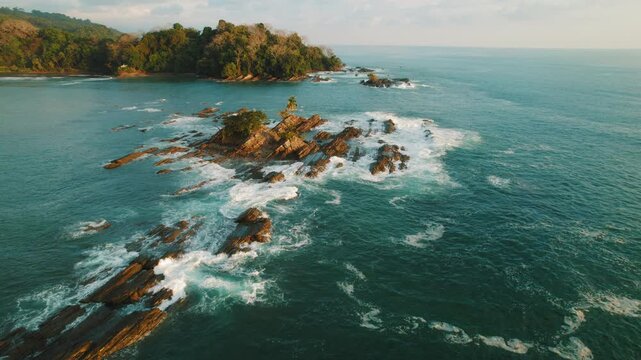 Rocky islets and turquoise ocean waves near Dominicalito beach in Costa Rica