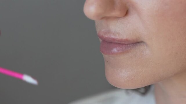 Professional Makeup Artist Applying Lip Treatment With Microbrush Vertical video