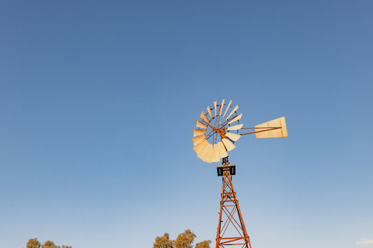 Vintage windmill with a clear blue sky background providing copy space