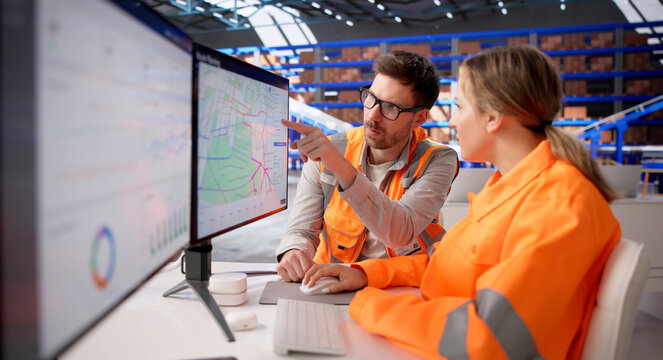 Warehouse Supervisor Monitors Digital Displays