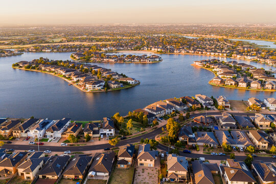Aerial view of waterfront housing around the shoreline of a lake in late afternoon sunshine