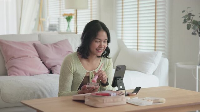 Asia people young gen z female happy smile enjoy phone apply selfie screen makeup blush virtual AI tech scan face app AR mixed augmented reality future beauty smart iot skin care help guide advice.