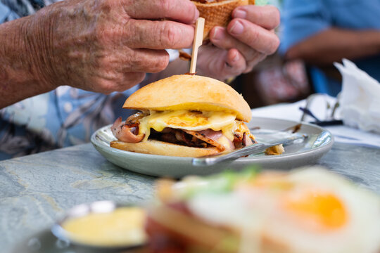 senior man enjoying a bacon and egg roll for brunch