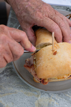 senior man enjoying a bacon and egg roll for brunch