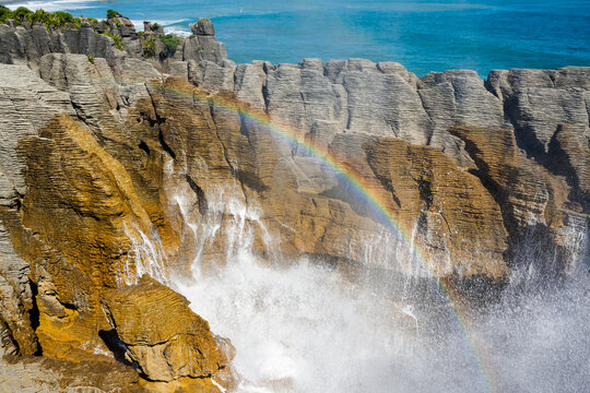 Coastal blow hole with rainbow and interesting rock formations