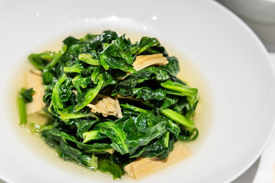 Serving of simple but delicious Chinese stir fried pea shoots or sprout vegetable in Beijing China