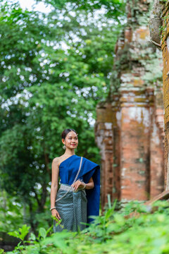 Asian Woman in Traditional Khmer Costume at Prasat Thom Temple in Koh Ker Cambodia Surrounded by Tree Roots