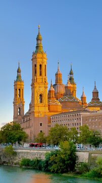 basilica of our lady of the pillar in zaragoza spain, historic cathedral on ebro river bank at sunset, majestic spanish architecture and landmark.