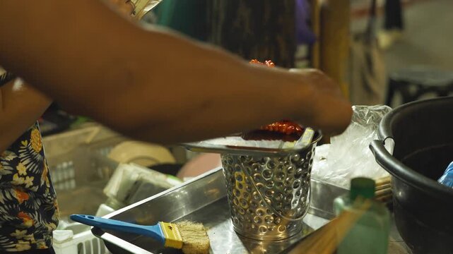 Filipino Street BBQ Vendor Listing Customer Orders at Night
